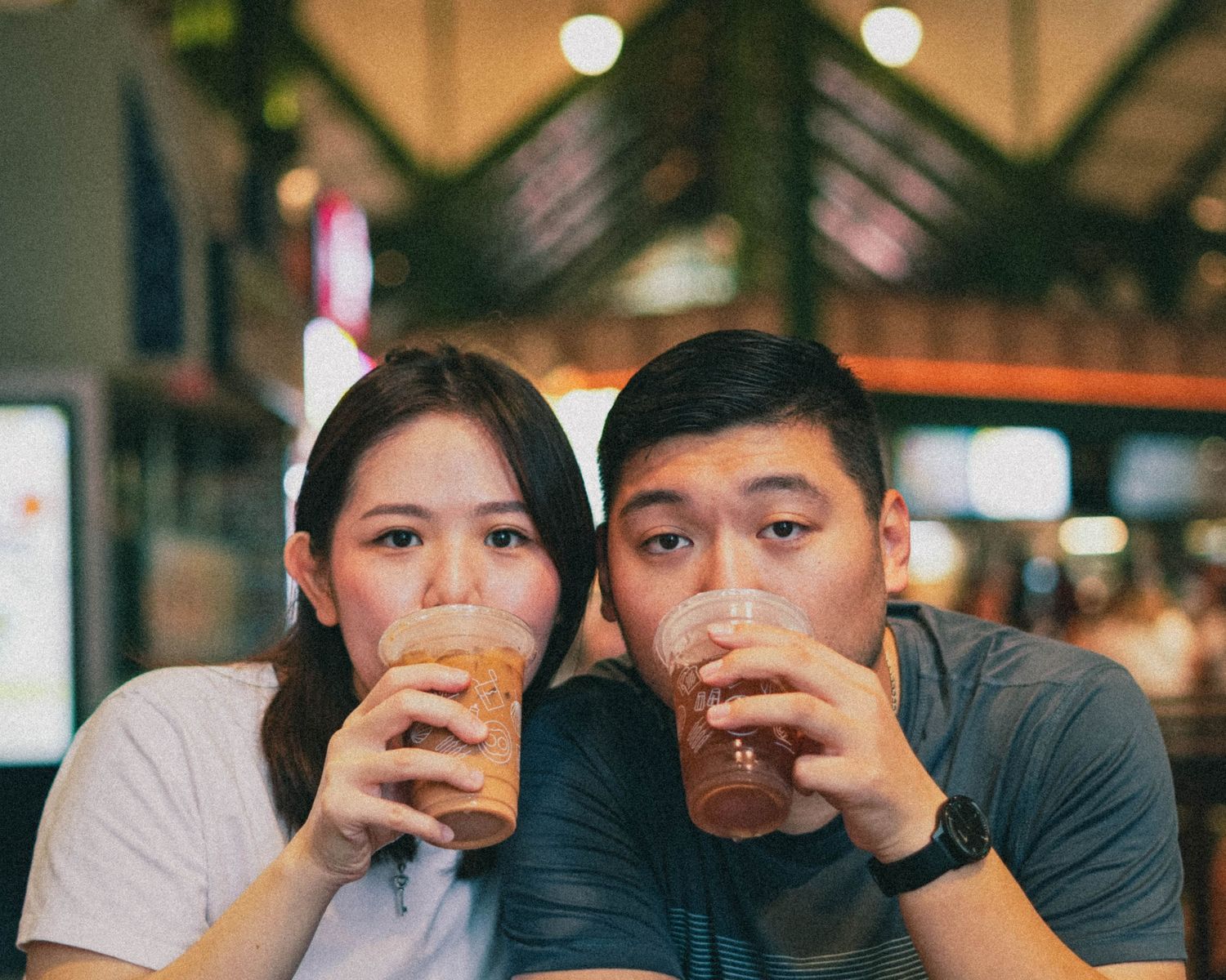 Two people enjoying beverages together at a restaurant with warm lighting.