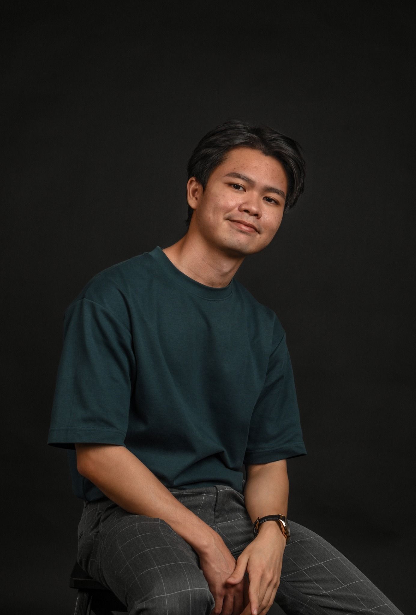 Portrait photos against black background show a person in dark shirt and plaid pants in various relaxed seated poses.