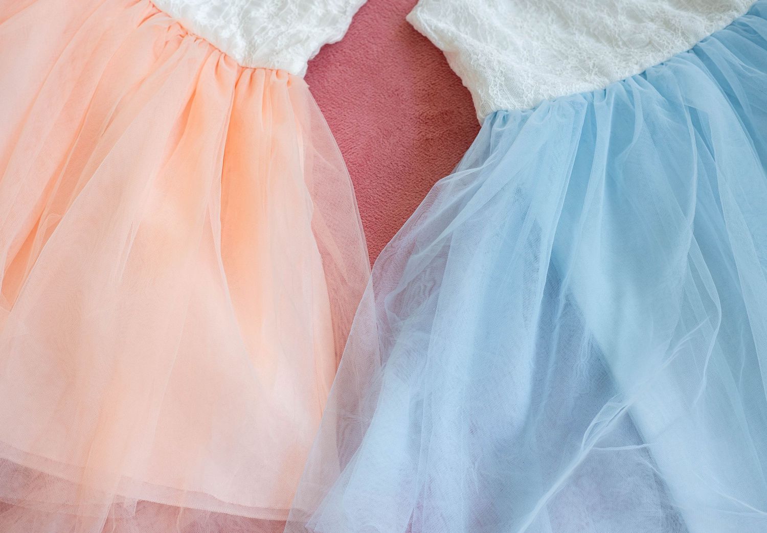 Close-up view of pink and blue tulle fabric skirts with delicate layers and soft textures.