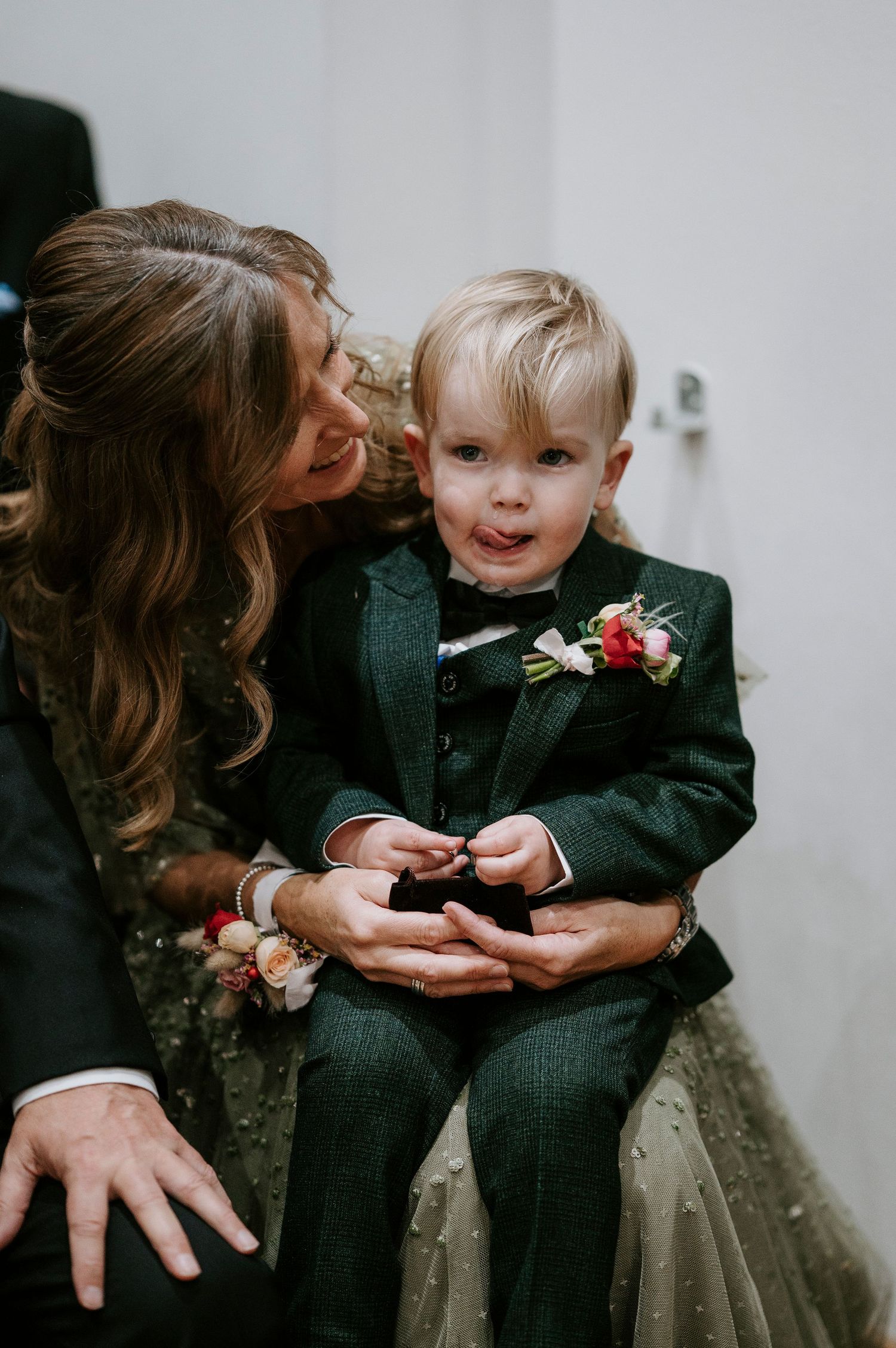 A series of intimate moments between a parent and child wearing formal attire and sharing a boutonniere.