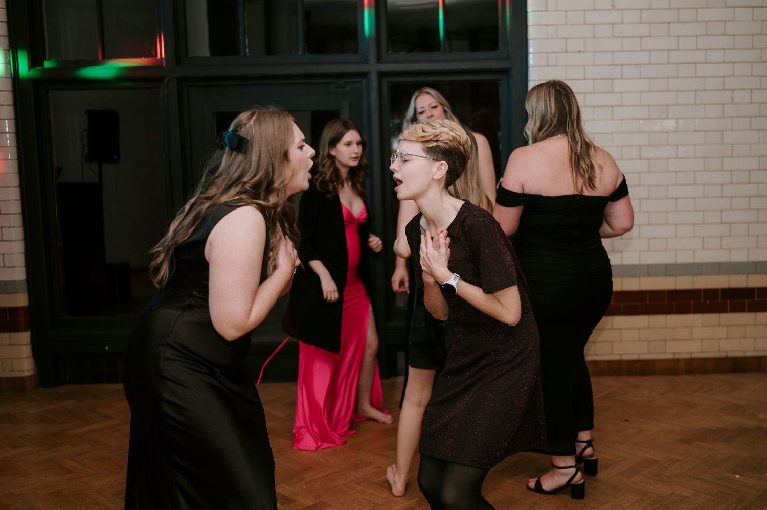Guests enjoying a lively dance party at an indoor wedding reception.