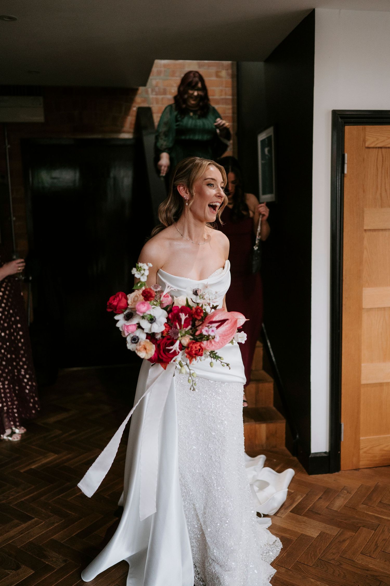 A wedding dress adorned with red and white floral arrangements captured in a sequence of artistic detail shots.