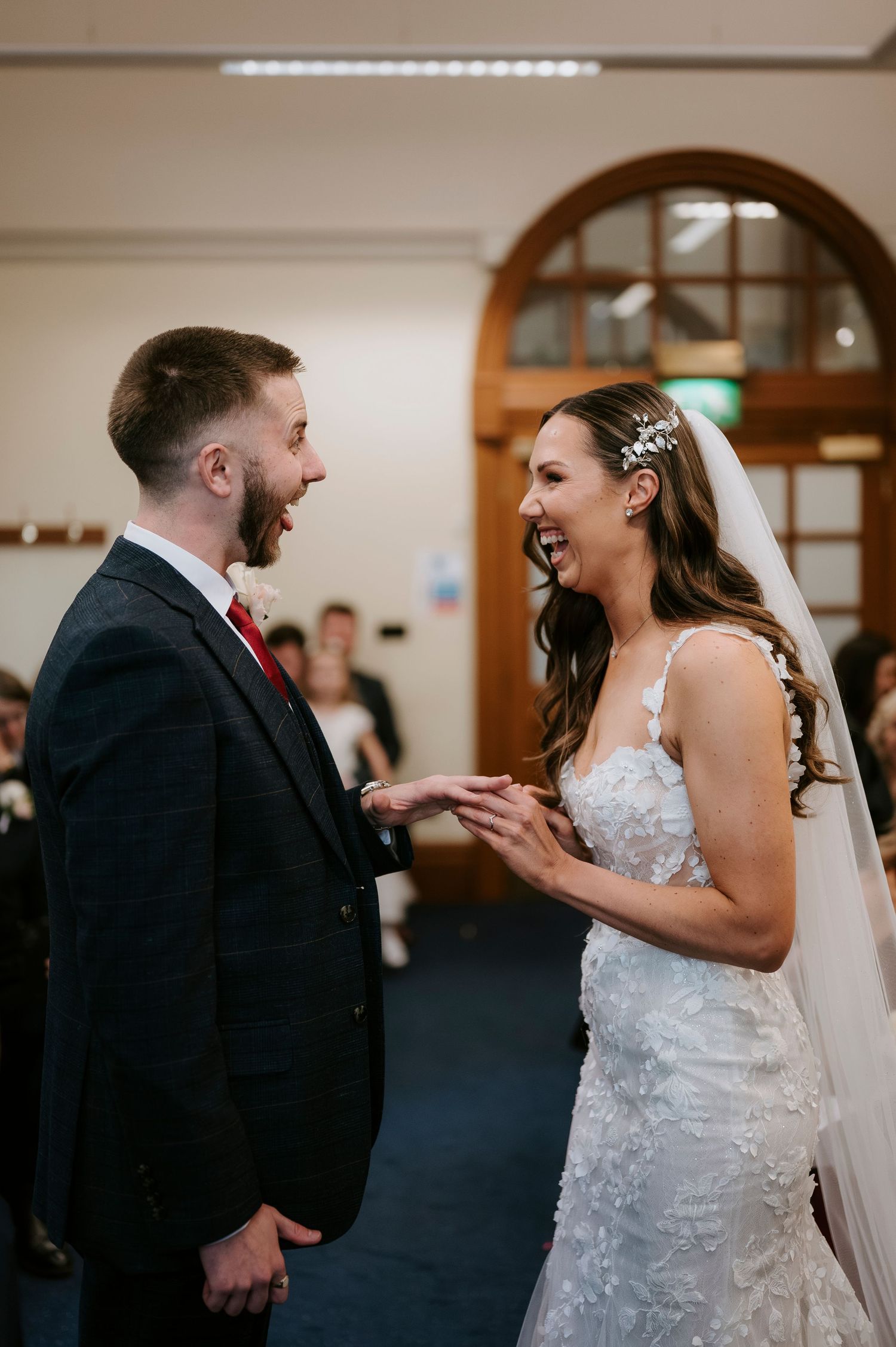 A joyful moment shared between a couple during their wedding ceremony as they exchange rings.
