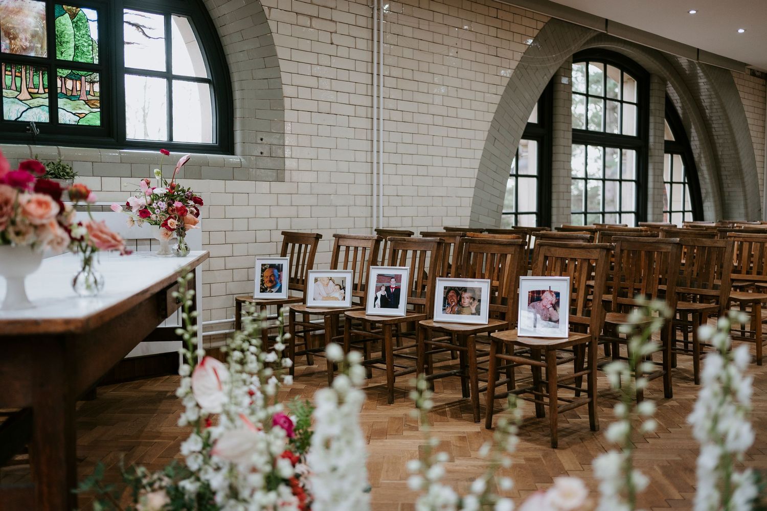 Interior of a rustic church with exposed brick walls, wooden pews, and floral arrangements for a wedding ceremony.