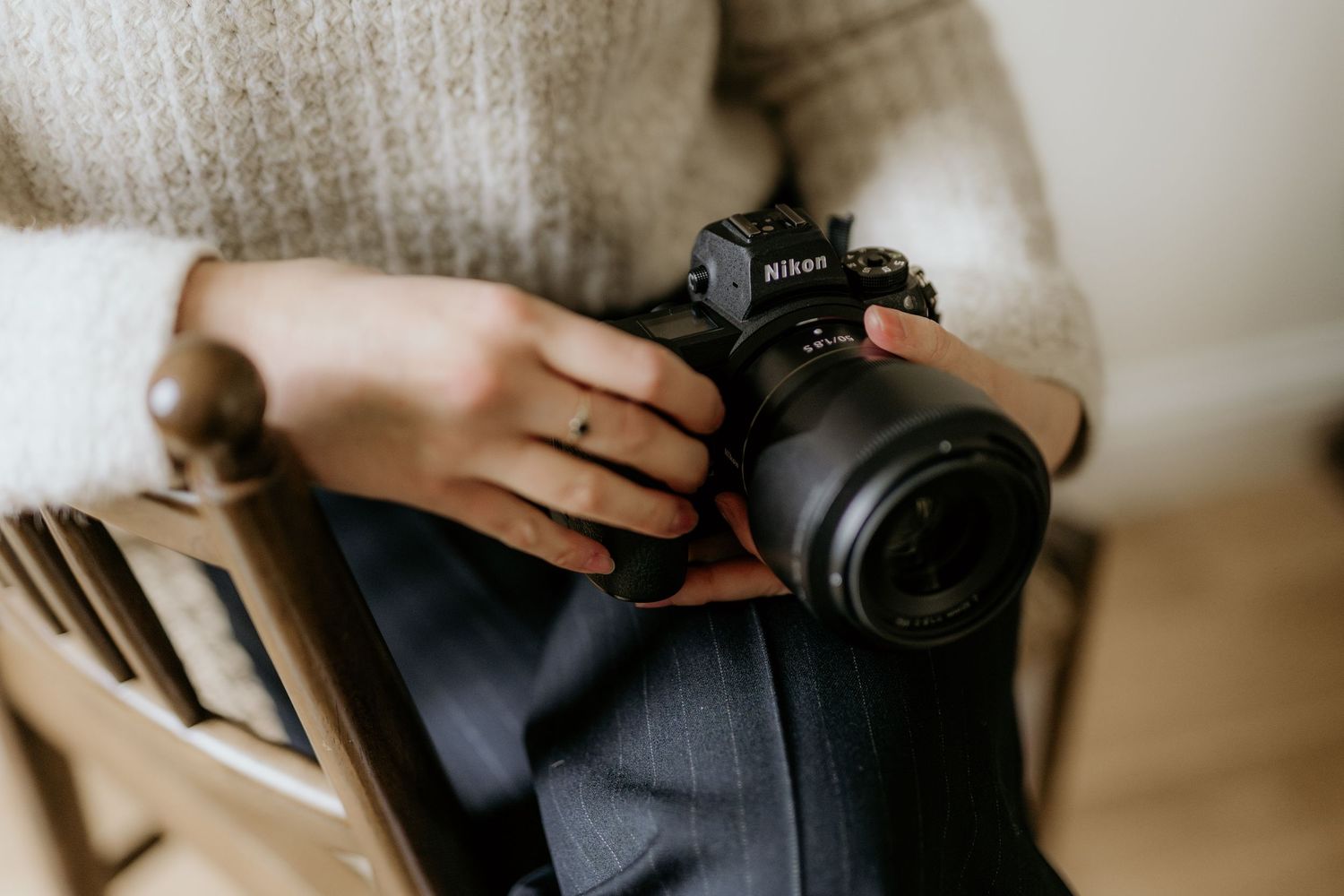 Close-up shots of hands holding a professional DSLR camera in various angles and positions.