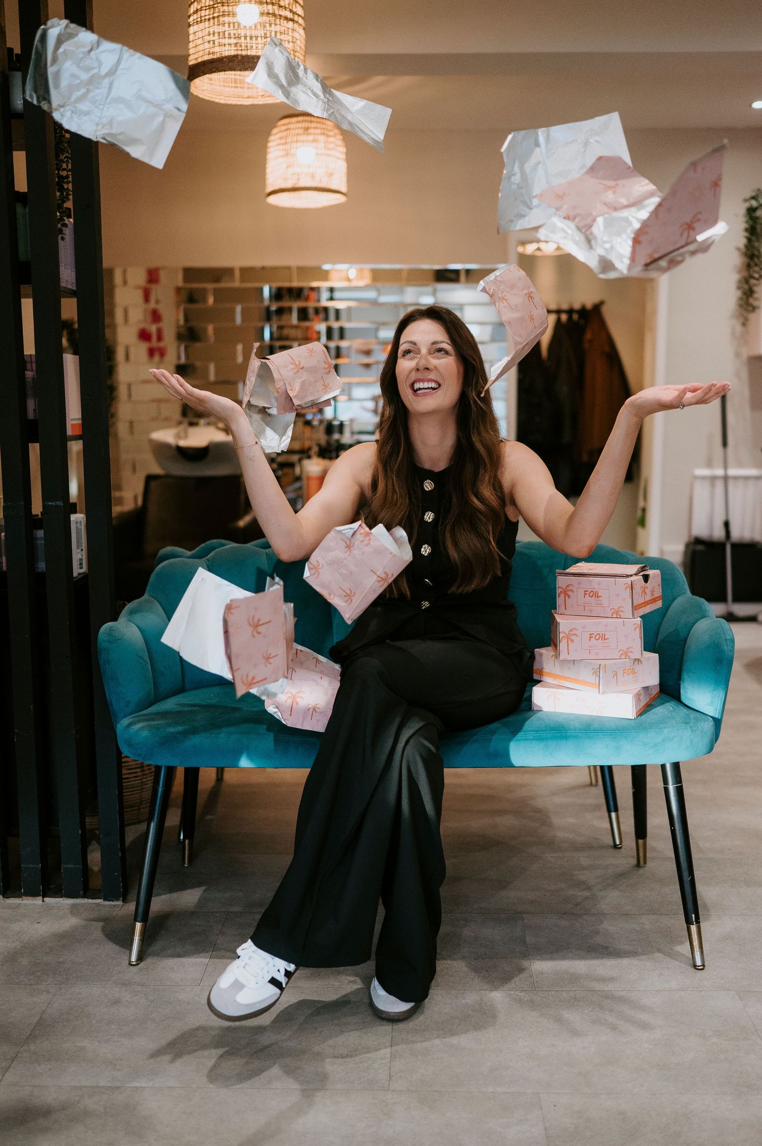 A joyful scene with papers flying through the air in a room with teal chairs and warm lighting.