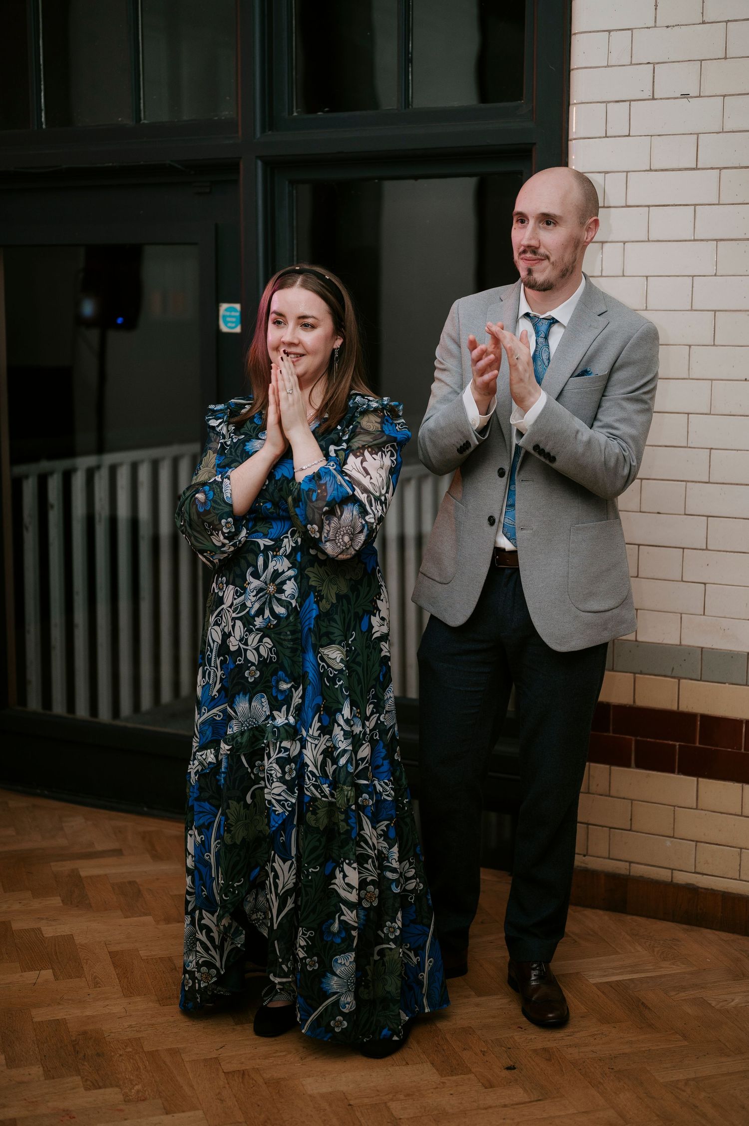 Wedding guests react with excitement and applause during a reception celebration.