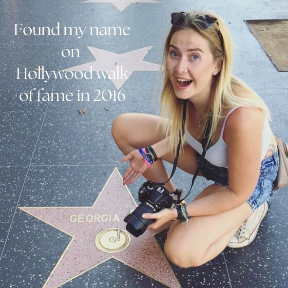 Tourist poses excitedly next to a star on the Hollywood Walk of Fame labeled 'GEORGIA' in Los Angeles, California.