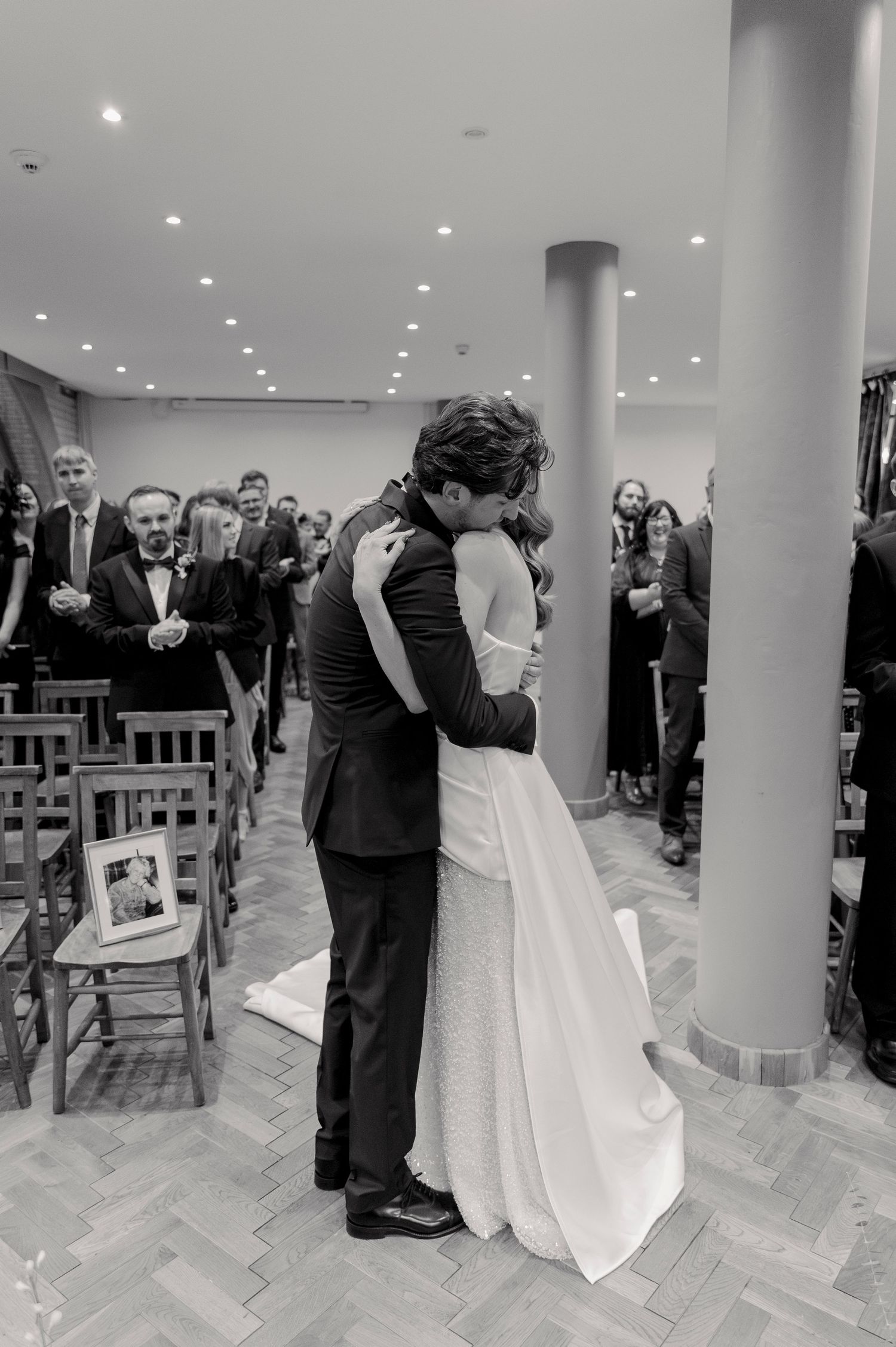 Black and white wedding photos showing joyful dance moments between newlyweds in a columned reception space.