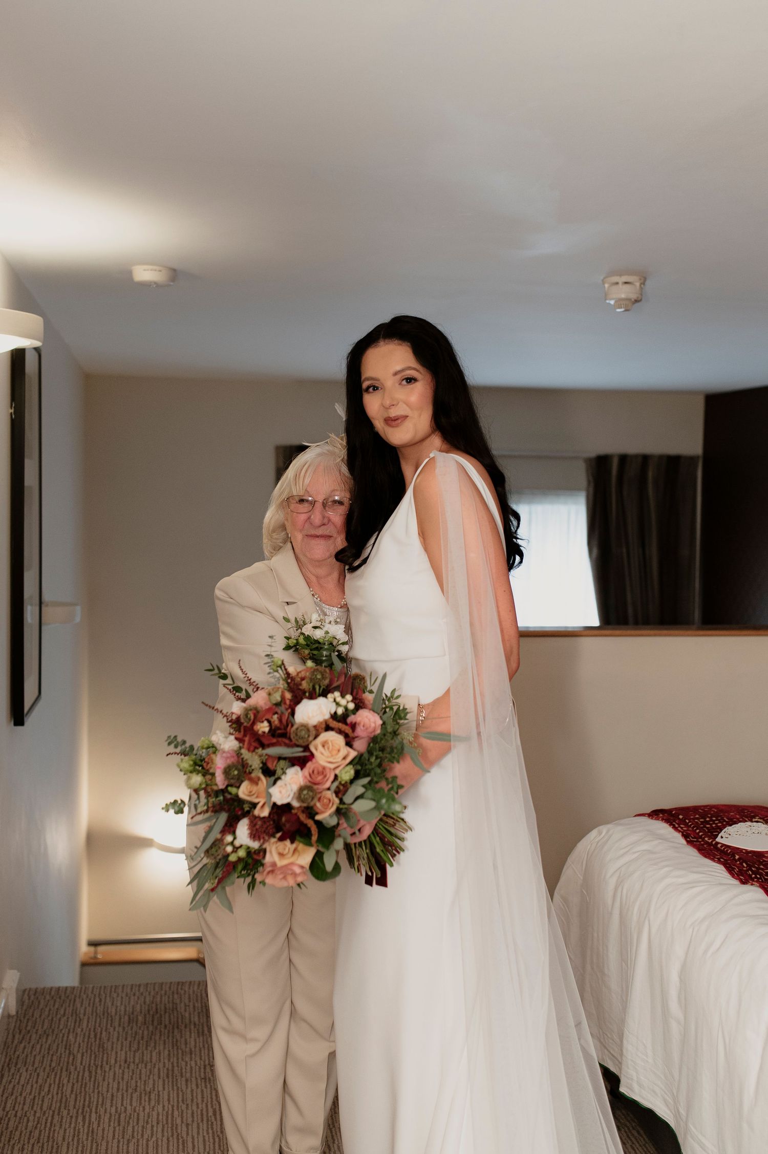 Getting ready moments in a bright hotel room with flowing white wedding gown.