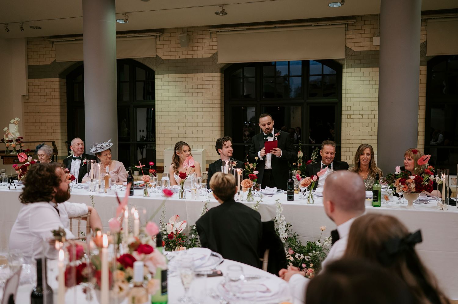Large reception hall with multiple round tables set for a formal dinner event.