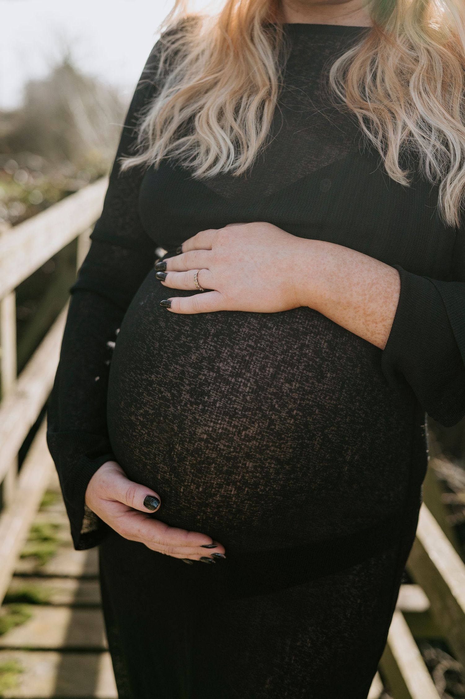A series of intimate maternity photos showing a pregnant belly in a black sweater against natural lighting.