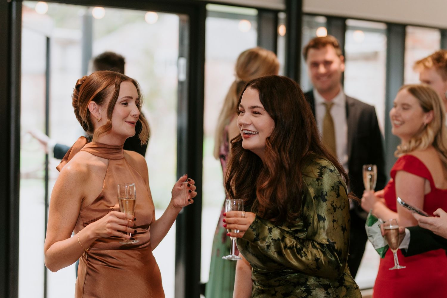 A group of people enjoying drinks and conversation at an elegant social gathering in formal attire.