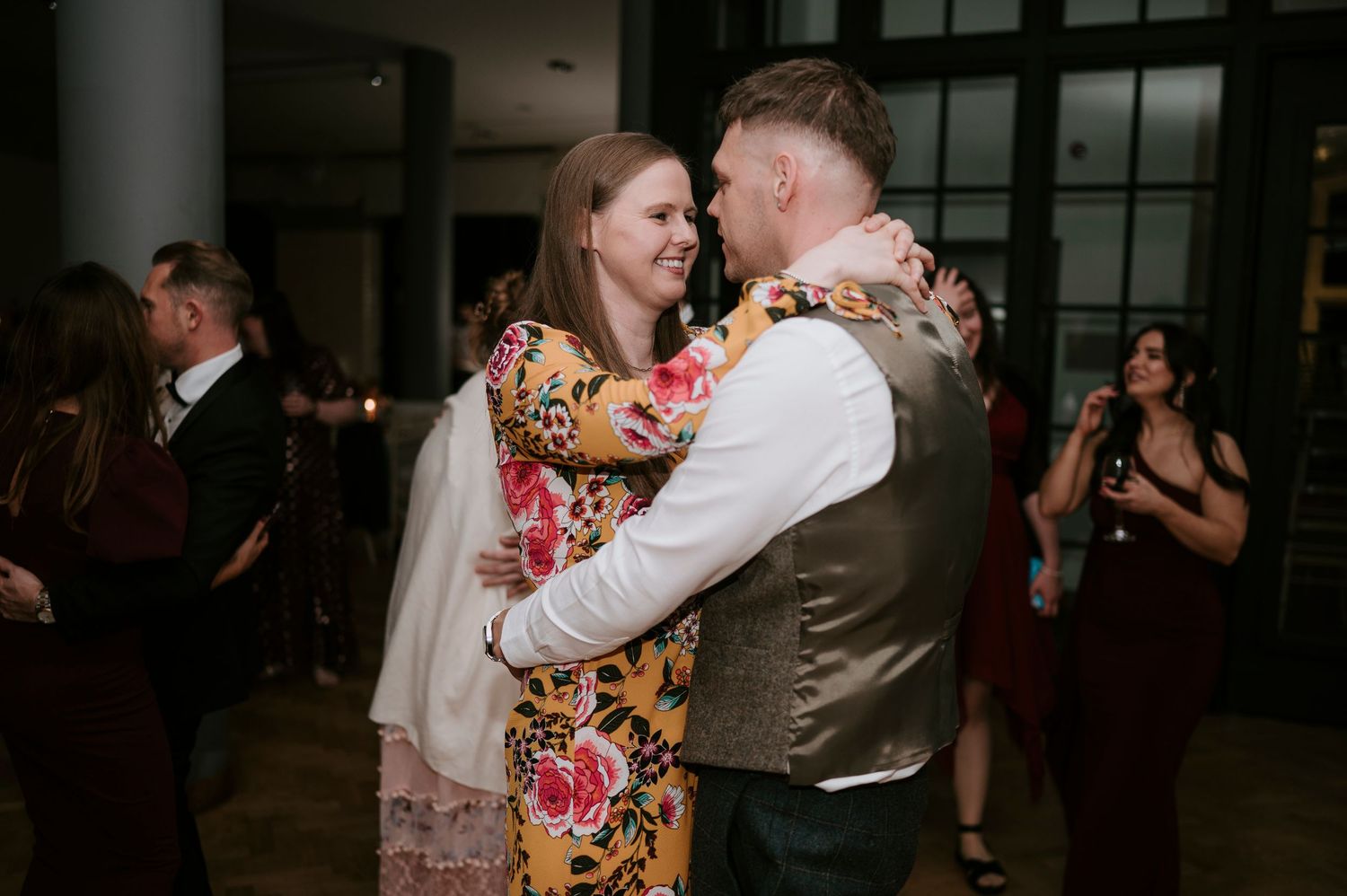 Wedding reception dance floor with guests celebrating in formal attire.