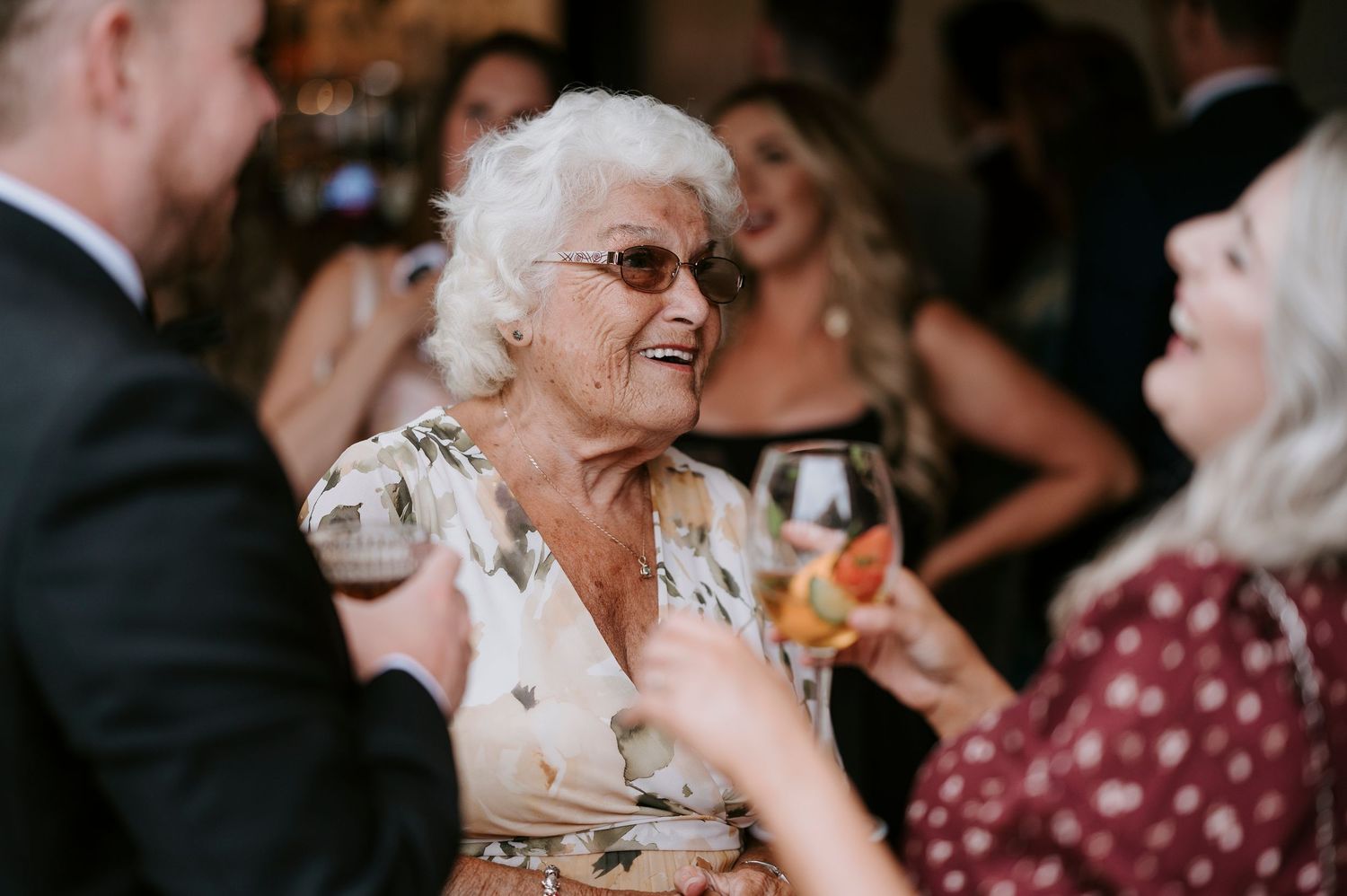 People dancing and celebrating at a wedding reception with guests enjoying themselves on the dance floor.