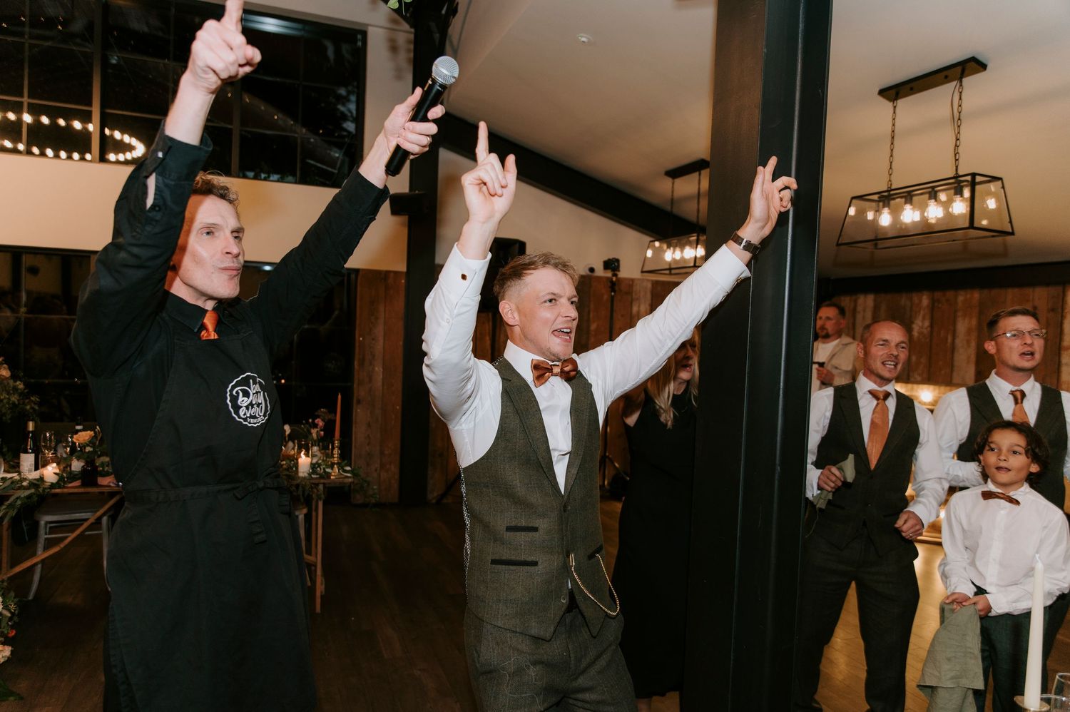 People raising their glasses in celebration during what appears to be a wedding reception or party event.