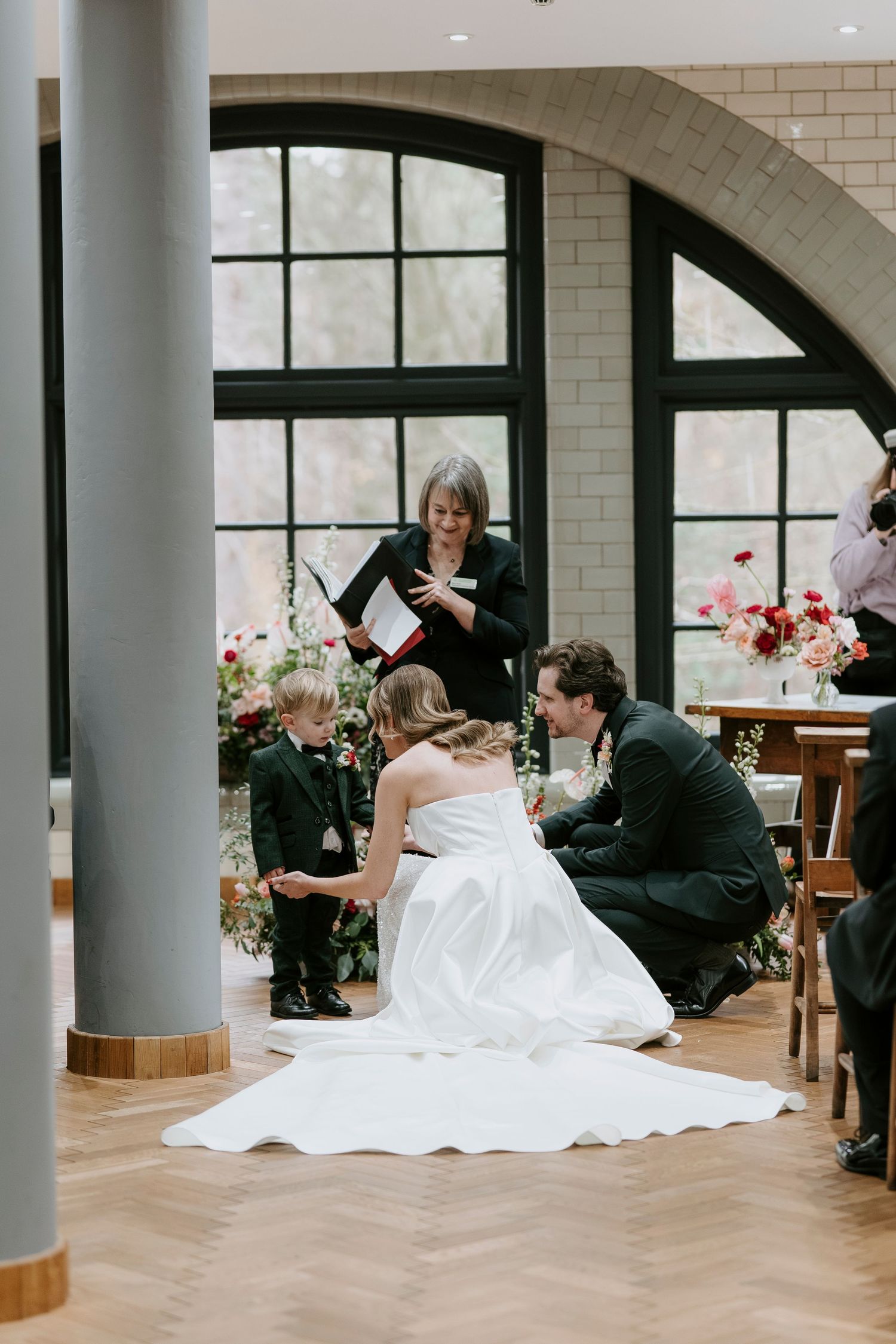 Wedding couple shares a romantic moment on the dance floor in an elegant venue with white brick walls.