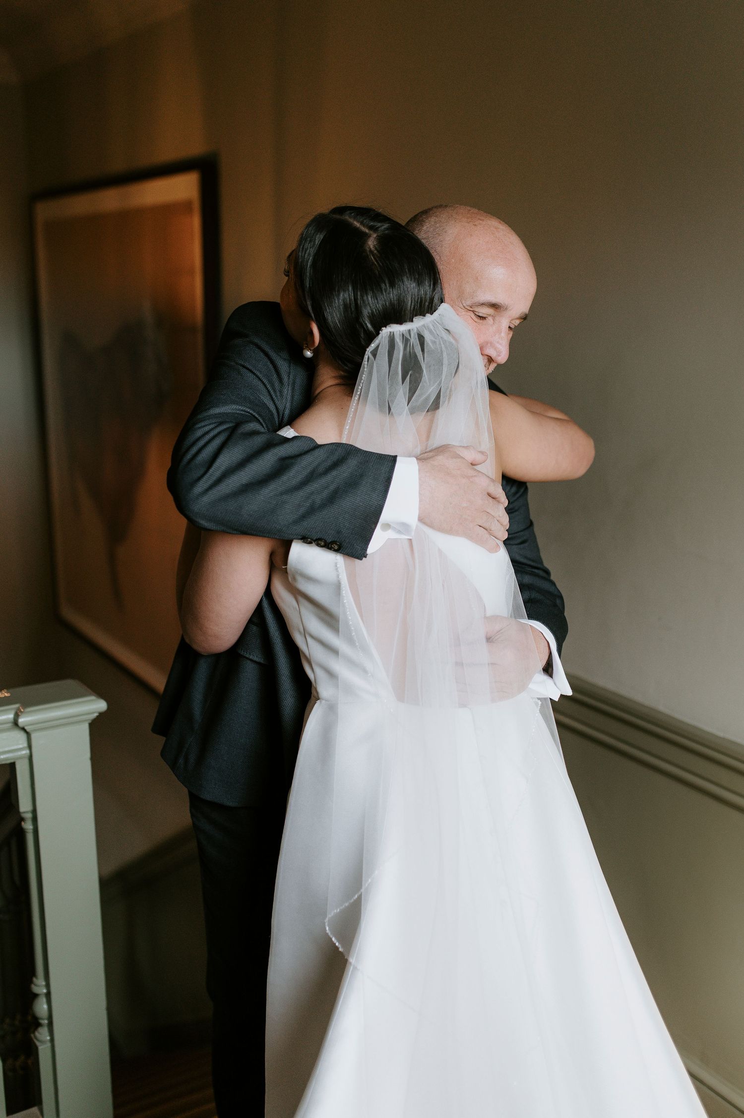A sequence of four wedding photos showing an emotional embrace between two people in formal attire.