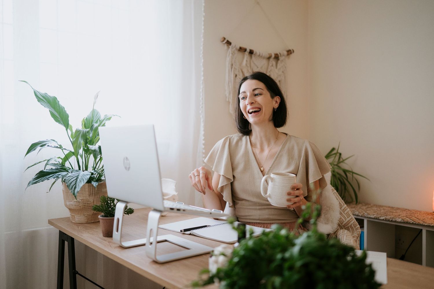 A series of connected images showing someone working at a bright minimalist desk with plants and a laptop setup.