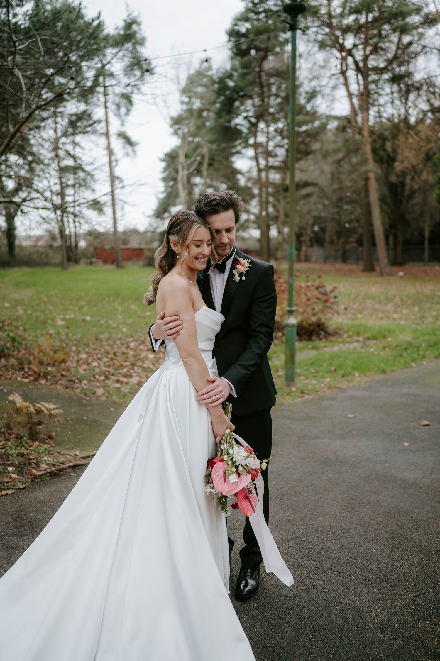 Romantic wedding couple shares intimate moments in a wooded outdoor setting with autumn foliage.