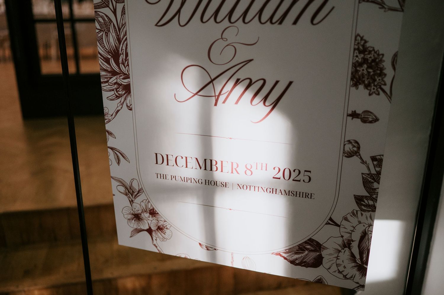 Wedding seating chart display with elegant floral designs and names printed on white panels against a dark background.