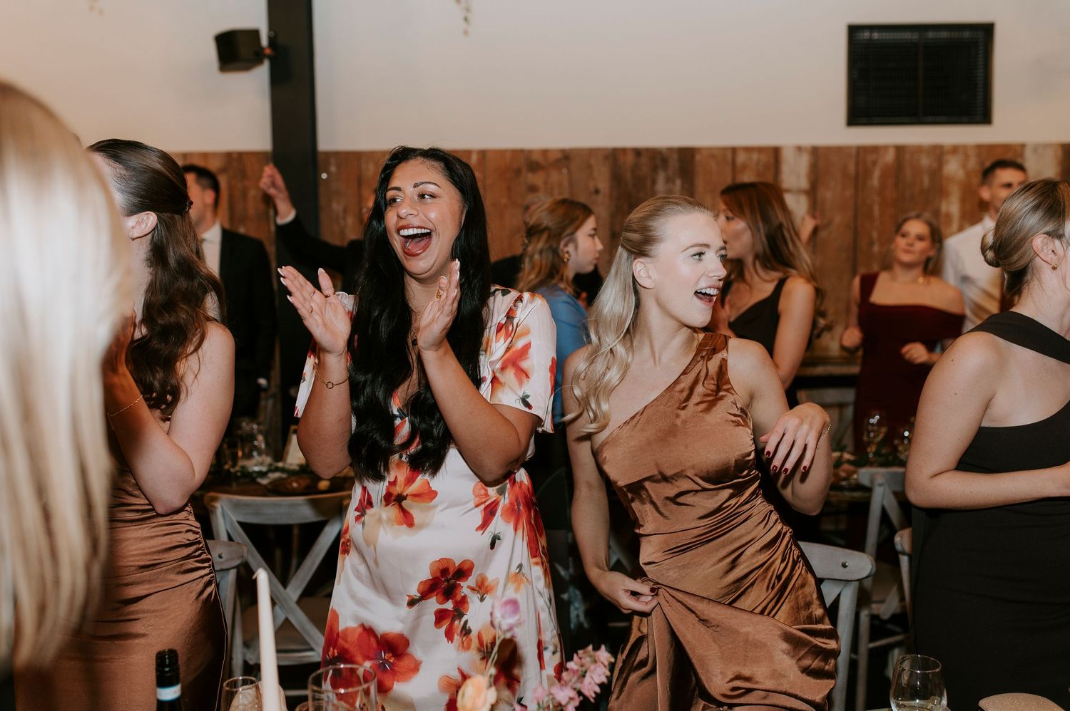 Wedding guests dance and celebrate together on a lively dance floor at a reception party.