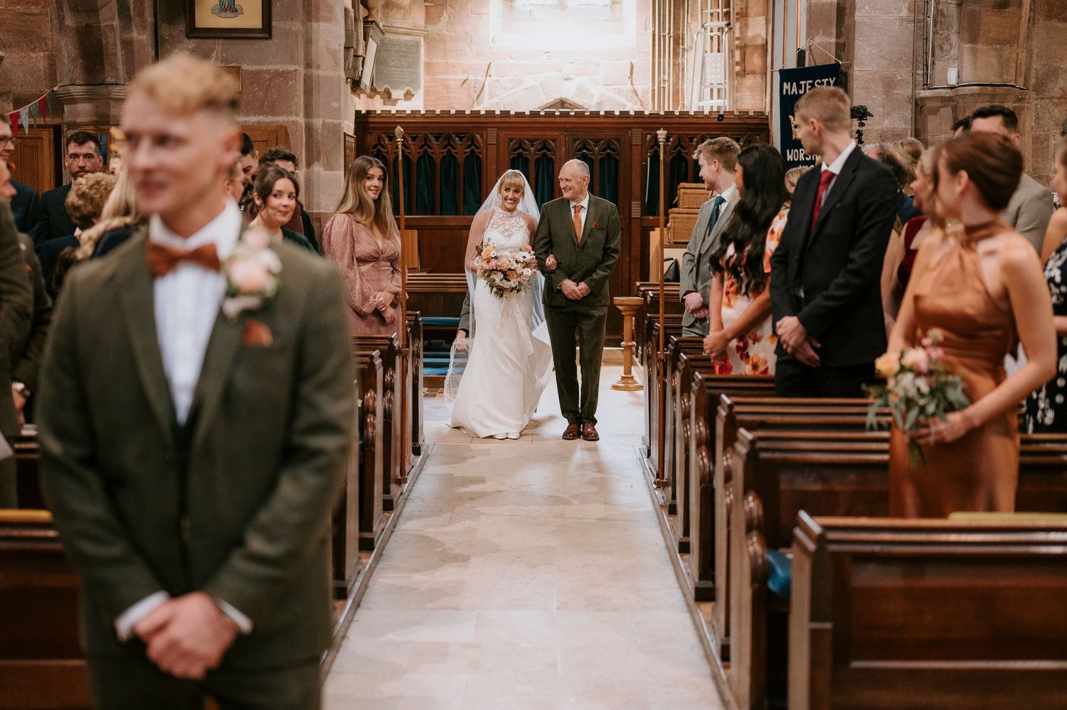 Guests seated in wooden pews during a traditional church wedding ceremony.