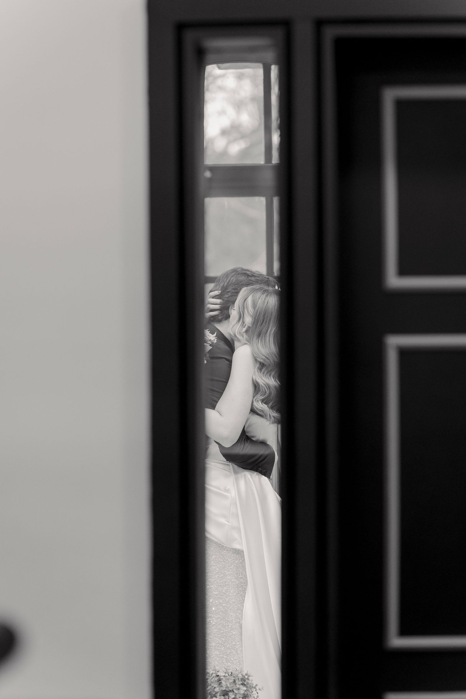 Black and white image showing a window reflection during wedding day preparations.