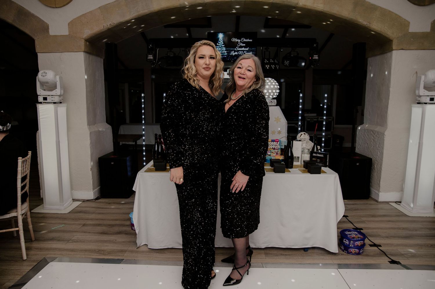 Wedding party dancing and celebrating on a polished dance floor at an indoor reception venue.