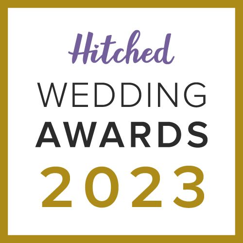 A square Hitched Wedding Awards 2023 logo with purple and black text on a white background with gold border.