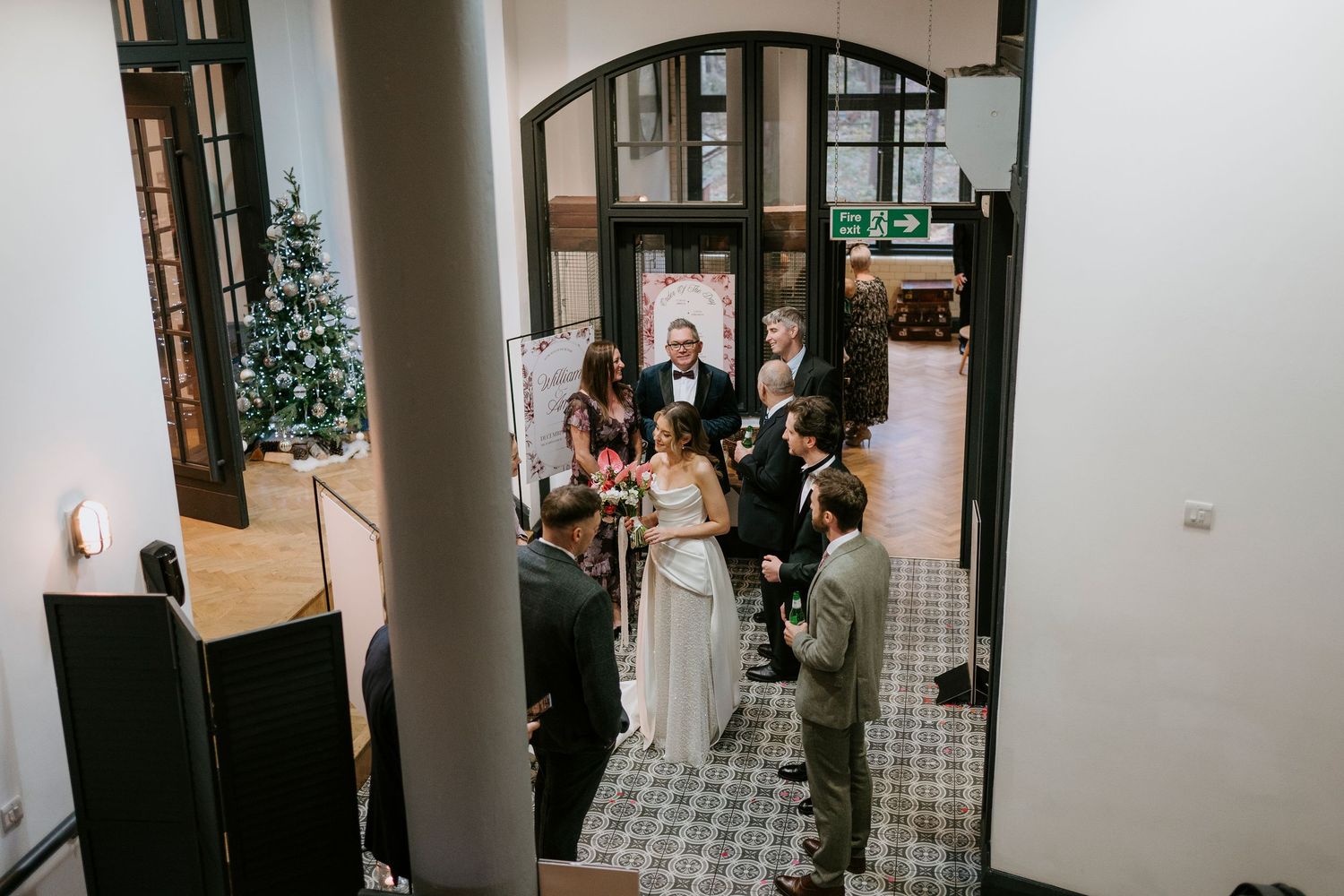 Interior hallway scene showing wedding preparations with white columns and tiled floor.