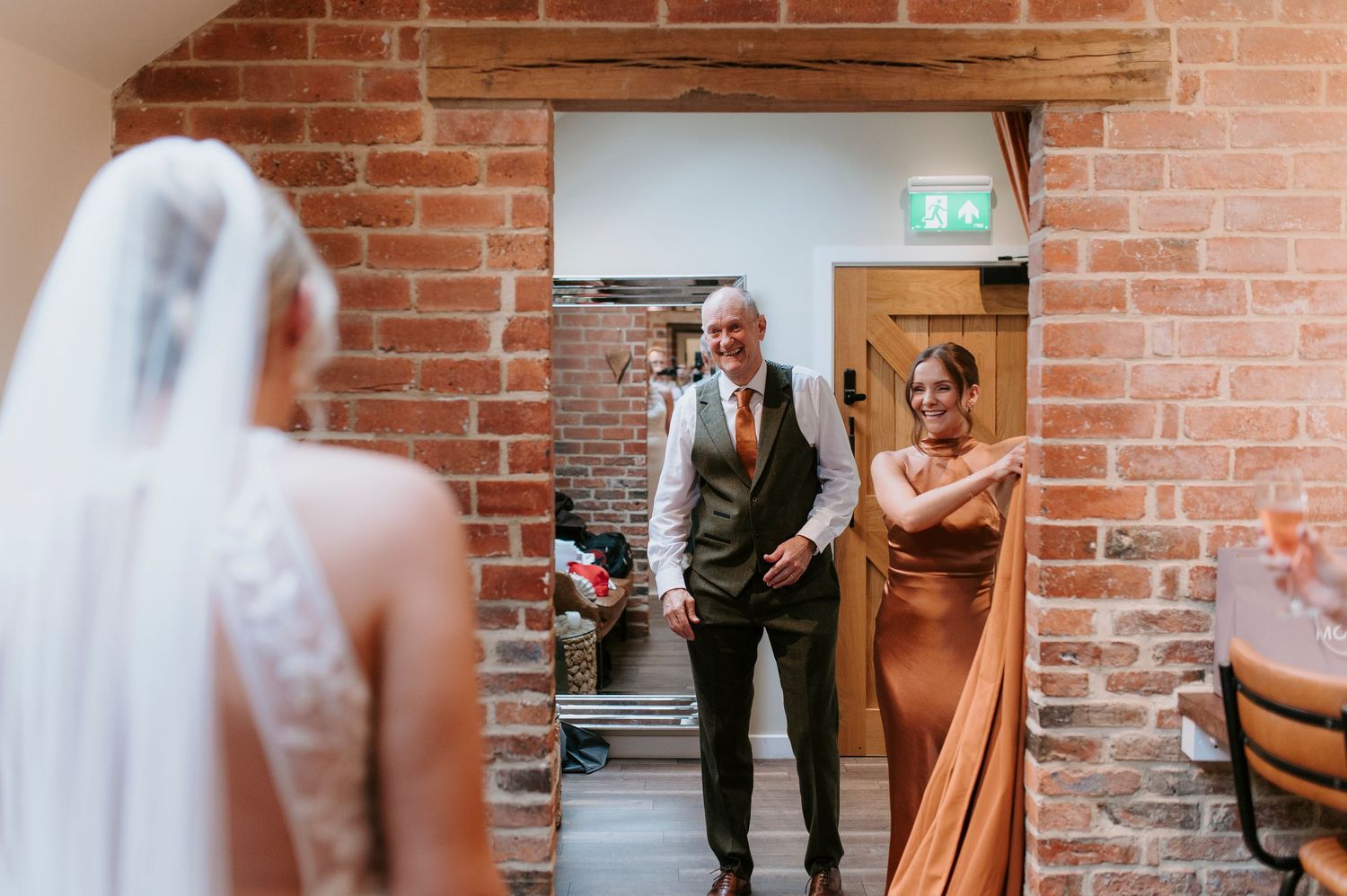 A sequence of candid wedding moments captured against a rustic brick wall backdrop at an indoor venue.