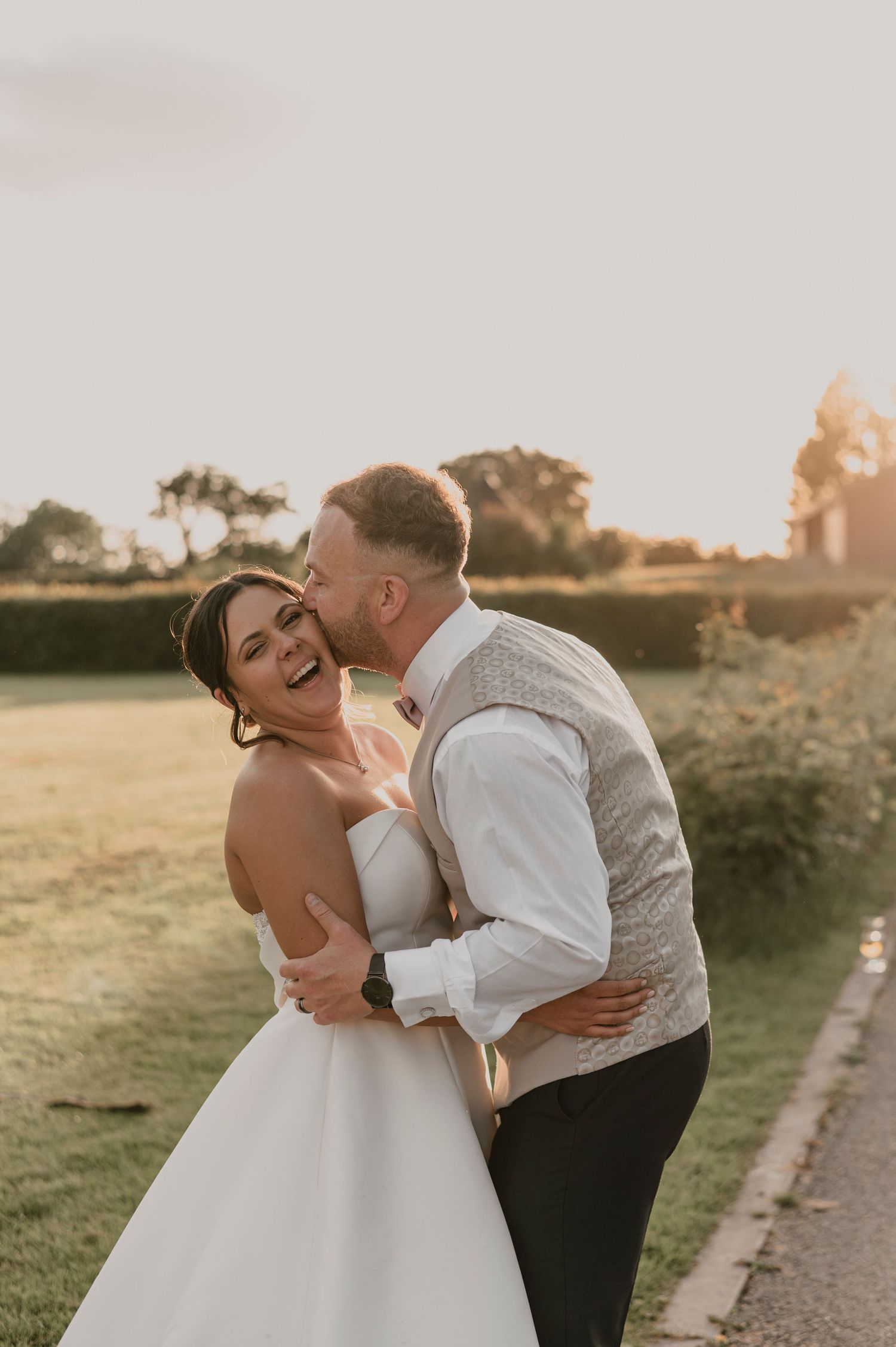 Romantic sunset wedding photos showing tender moments between newlyweds in a golden field.