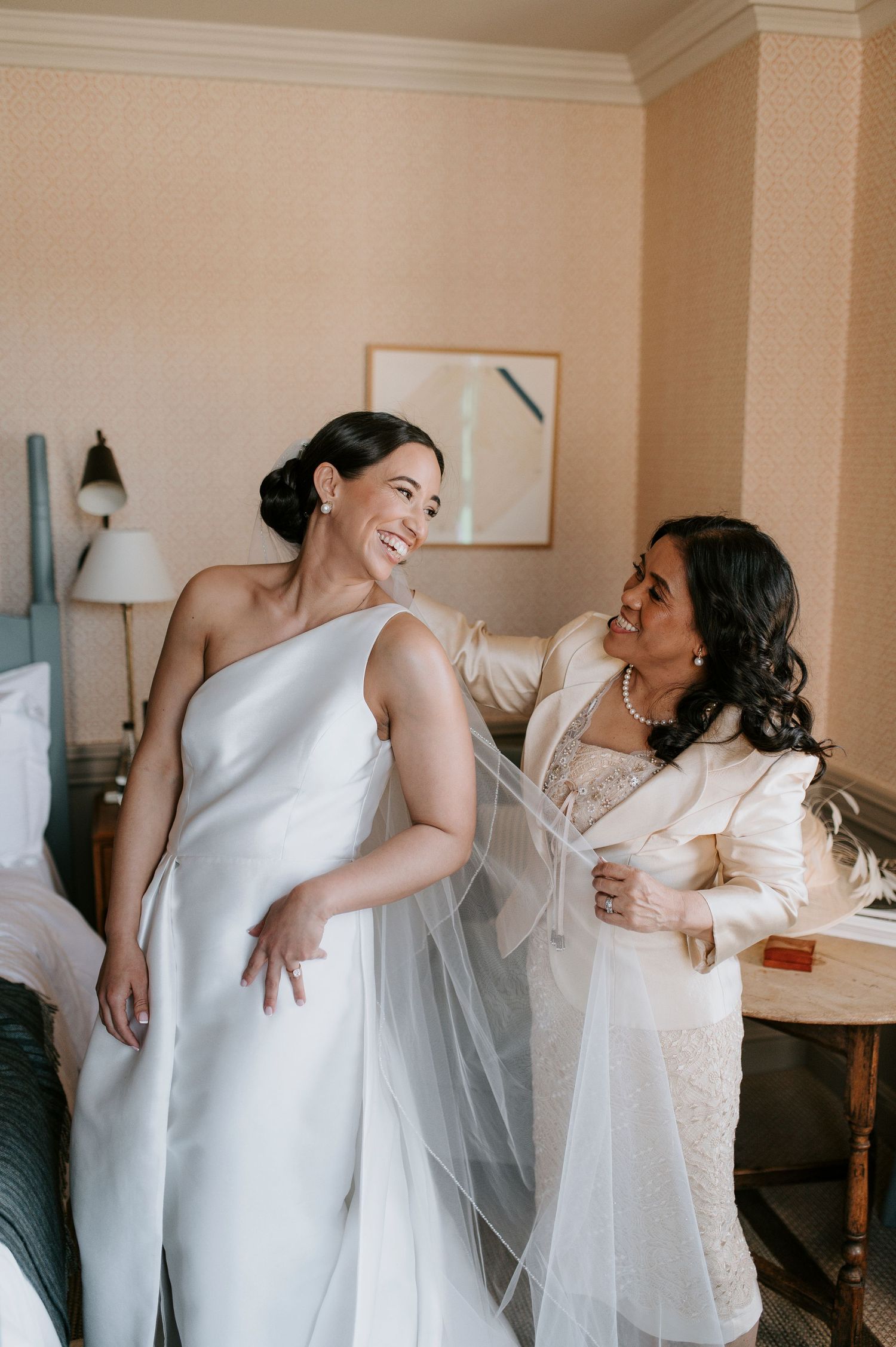 A series of candid moments showing two people in white dresses laughing and embracing during a wedding preparation.