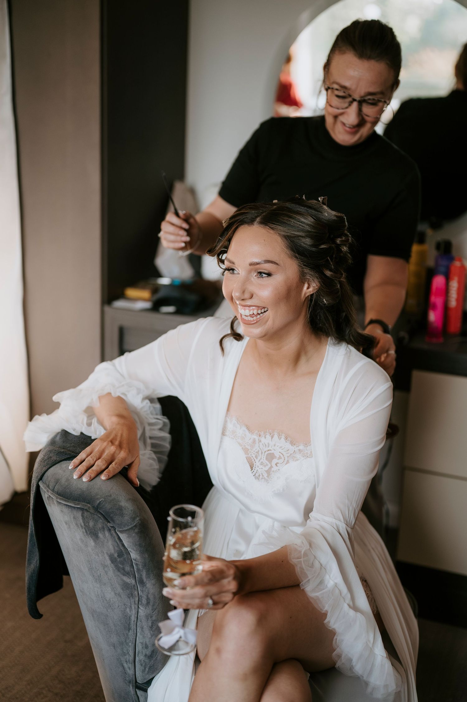 A series of candid wedding preparation moments showing a bride and bridesmaids getting ready in white robes.