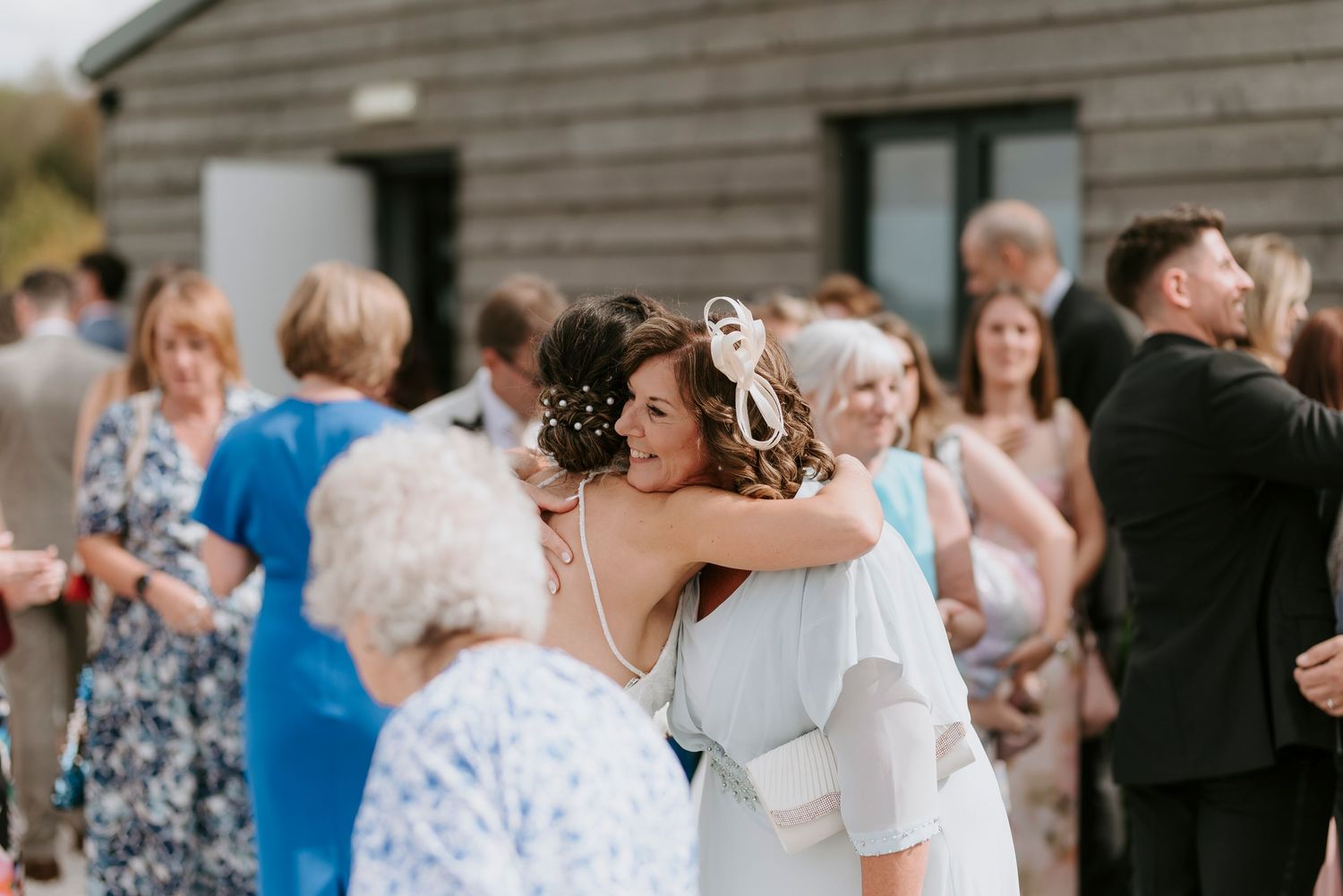 Wedding guests dance and celebrate together on the dance floor at an indoor reception venue.