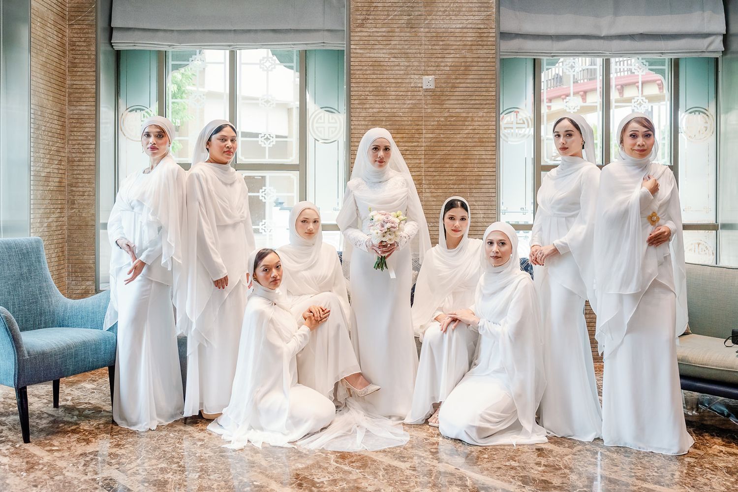 Malaysian  bride with bridesmaids all dressed in elegant white hijab gowns posing together.