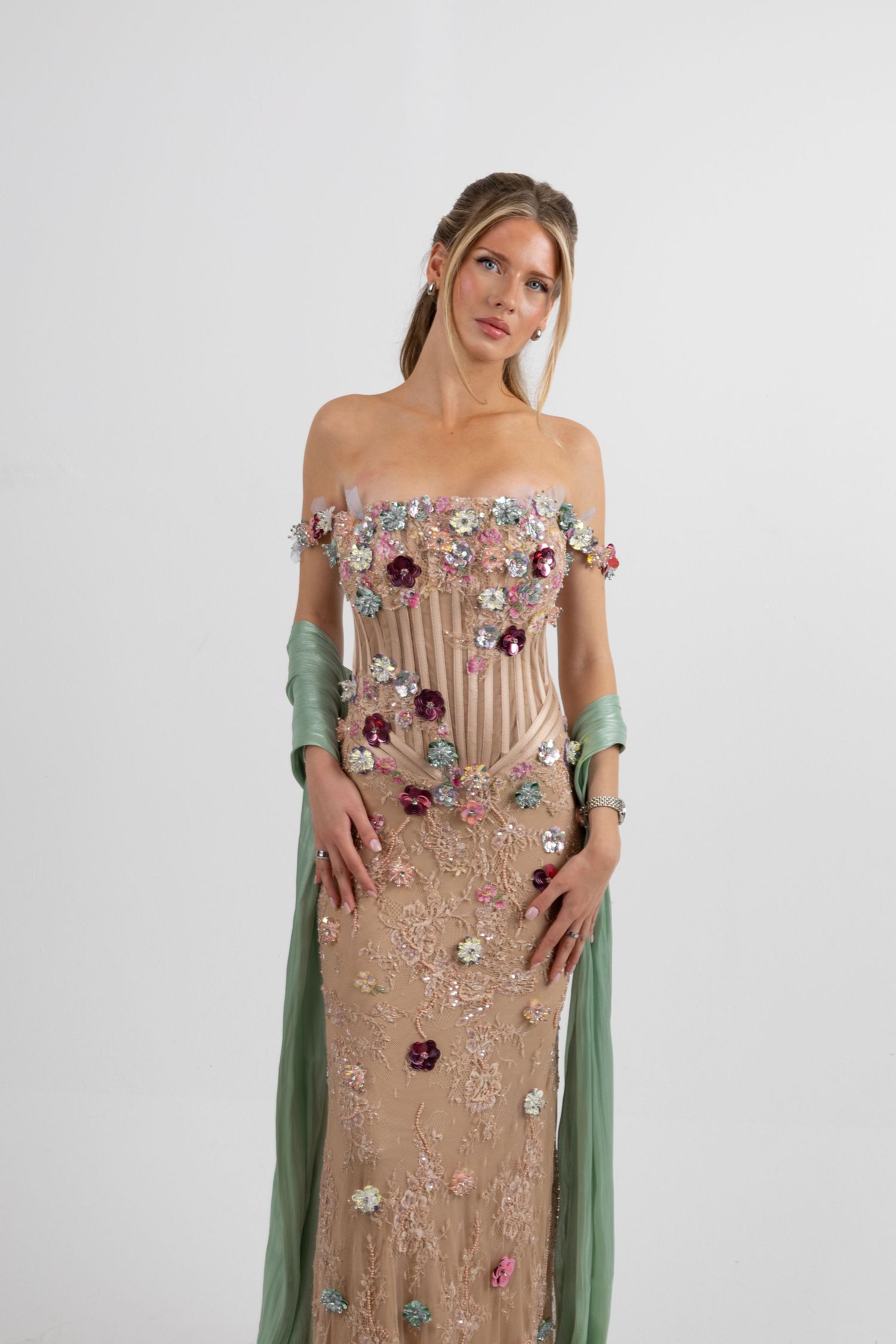 Elegant off-shoulder gown with 3D floral embellishments in pink and green tulle sleeves on a blonde model.