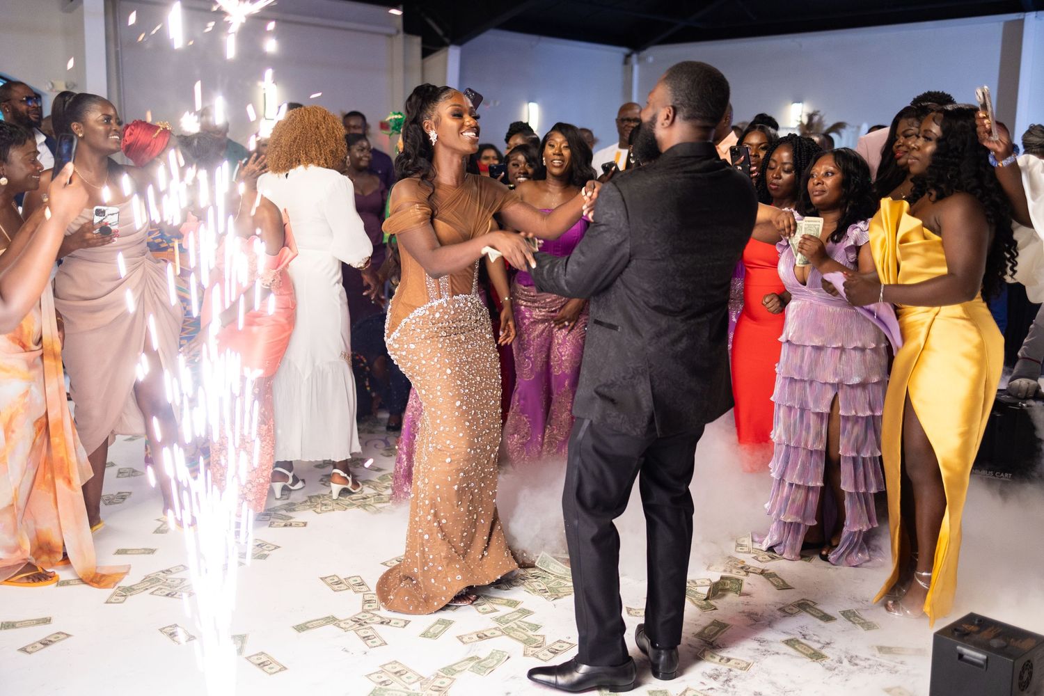 Wedding celebration with sparklers and fog effects creating a magical atmosphere on the dance floor.