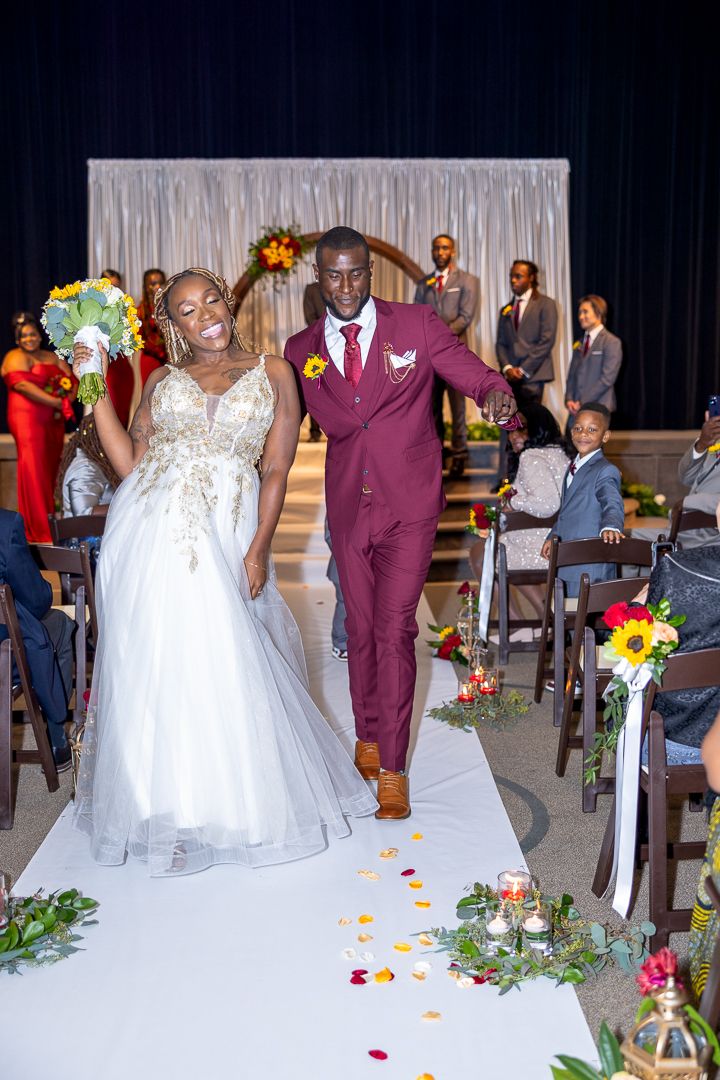 Wedding ceremony setup with a burgundy and white color scheme featuring floral decorations.