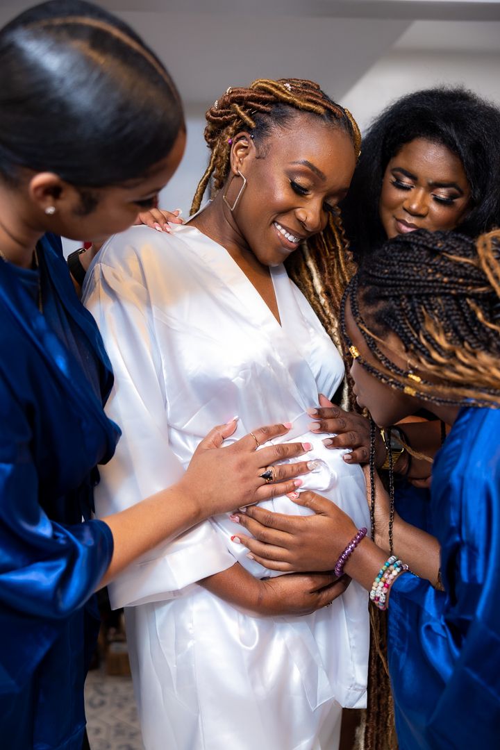 A tender moment between people wearing white and blue outfits during a special occasion.