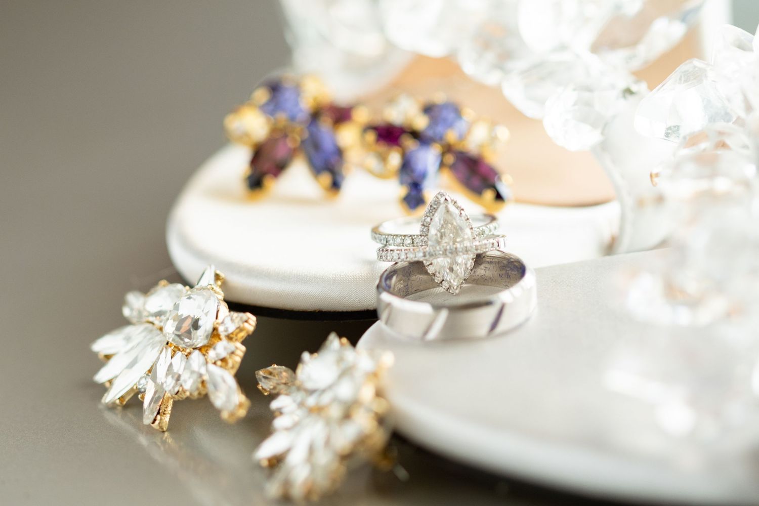 Close up of elegant wedding jewelry and rings with floral details.