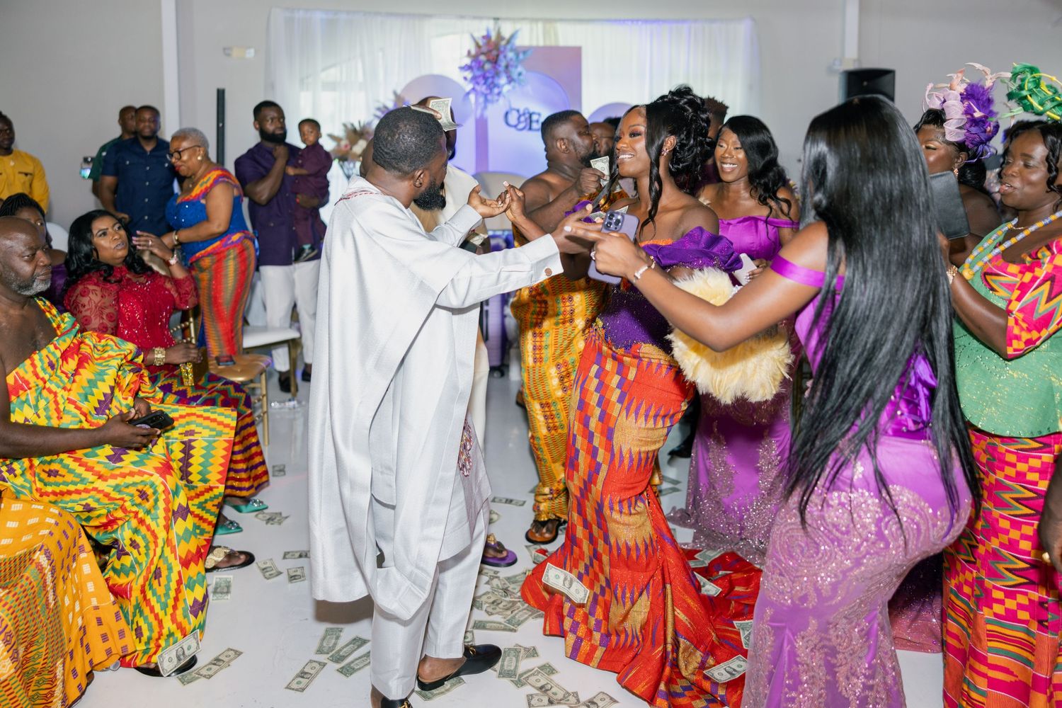 Dance party scene with guests in colorful African prints and formal attire.