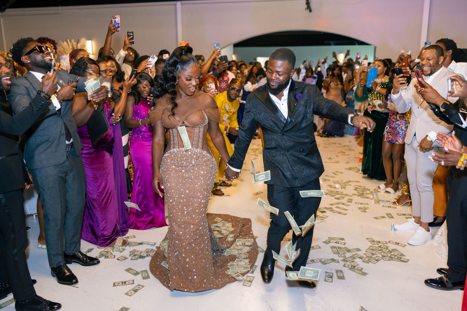 Wedding reception guests dancing and celebrating on a crowded dance floor with confetti scattered around.