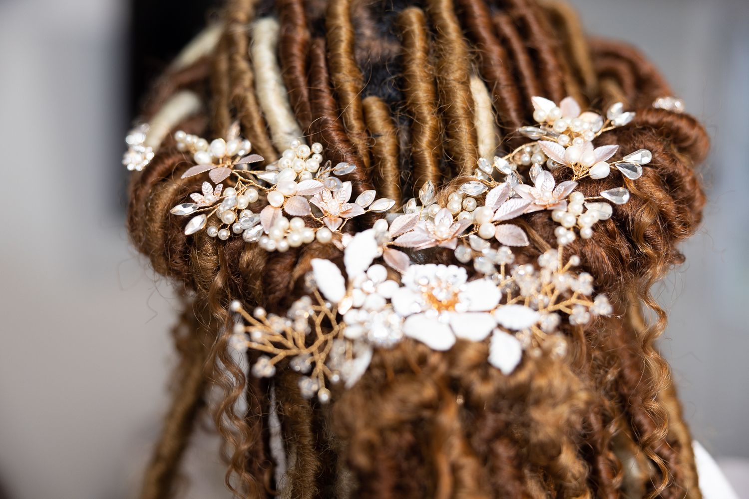 Delicate pearl and crystal floral hair accessory adorns braided hair with white blossoms.