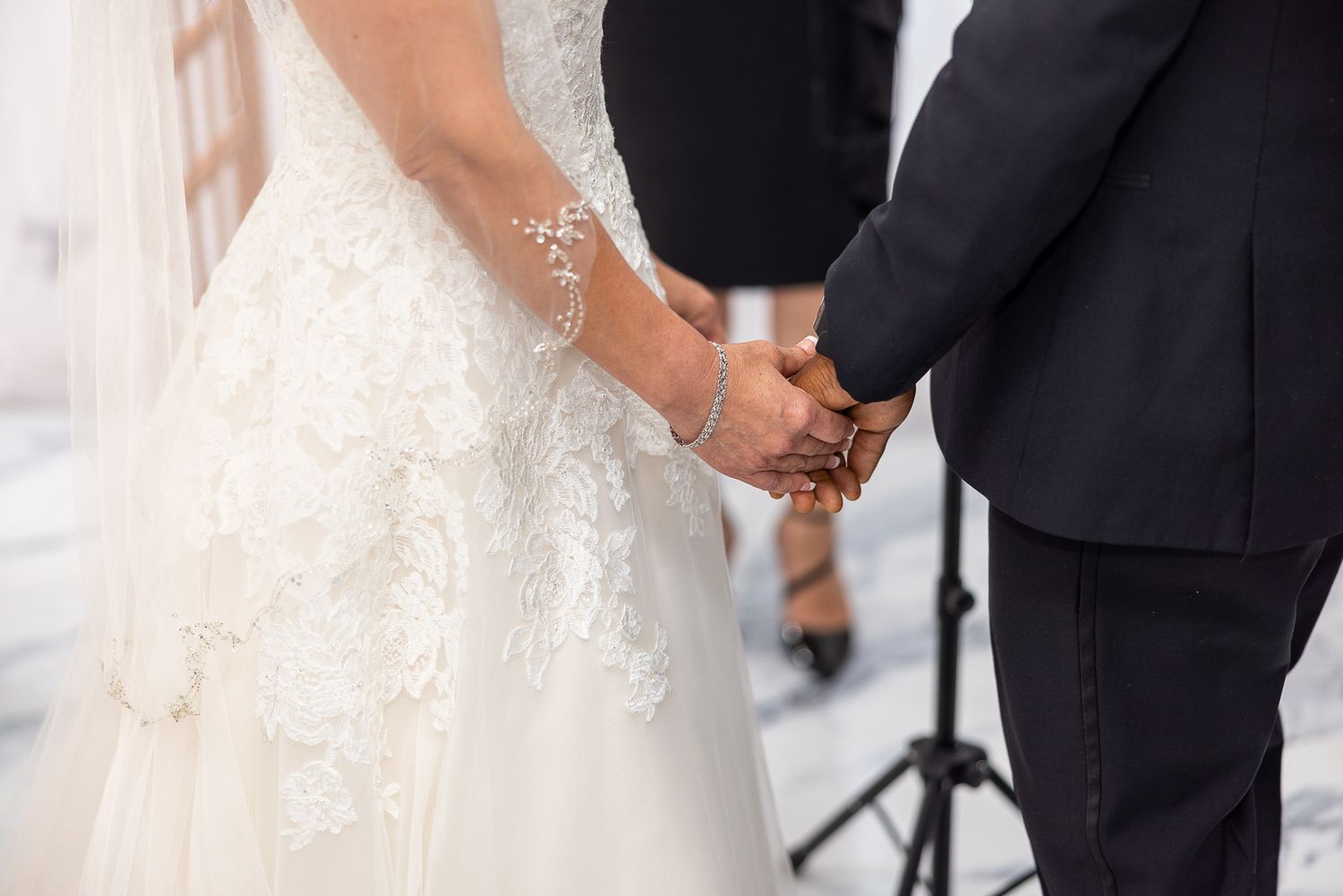 A couple exchanges vows under a floral arch during their wedding ceremony.