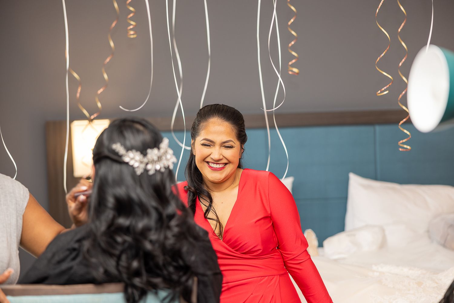 Wedding guests celebrate with confetti and smiles in a festive venue decorated with streamers.