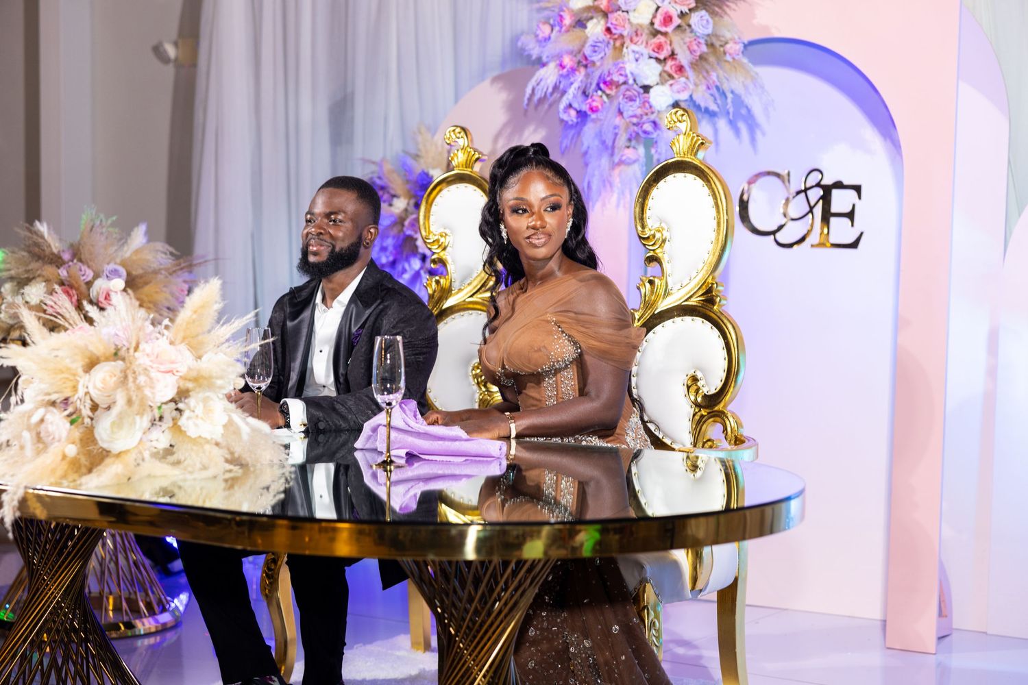 Luxurious wedding reception setup with ornate floral decorations and elegant lighting.