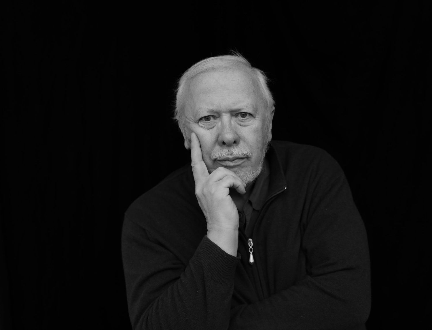 Series of black and white portraits showing contemplative expressions against dark background.