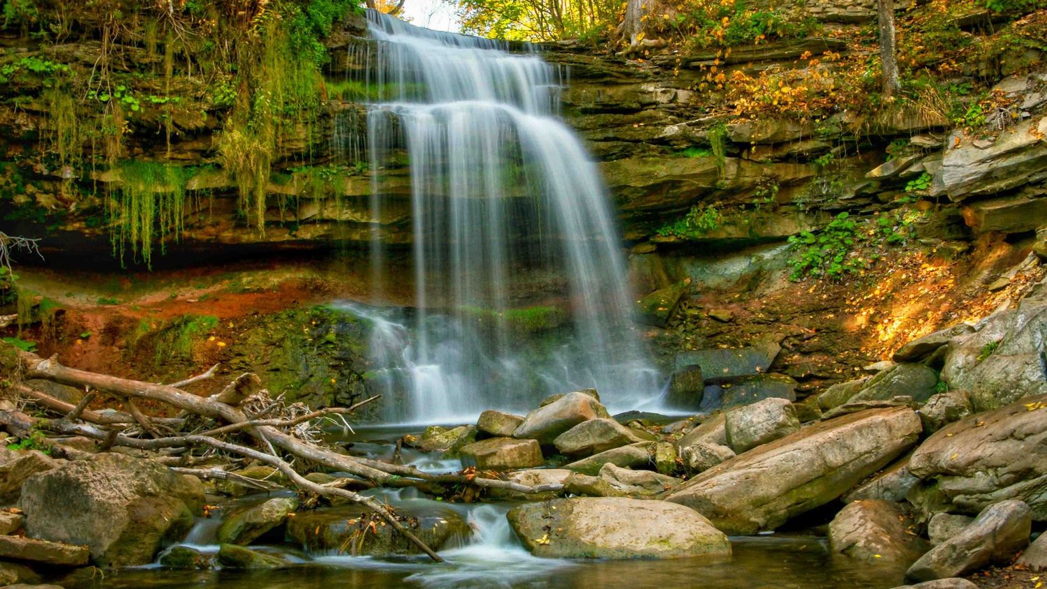 Panoramic view of a cascading waterfall flowing over rocky ledges in Watertown, Ontario
